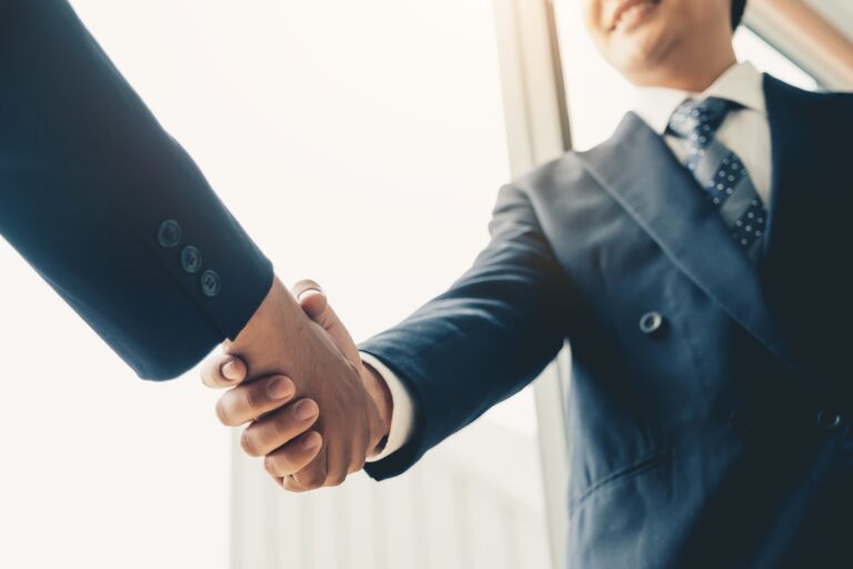 Two business man shaking hands during a meeting in the office